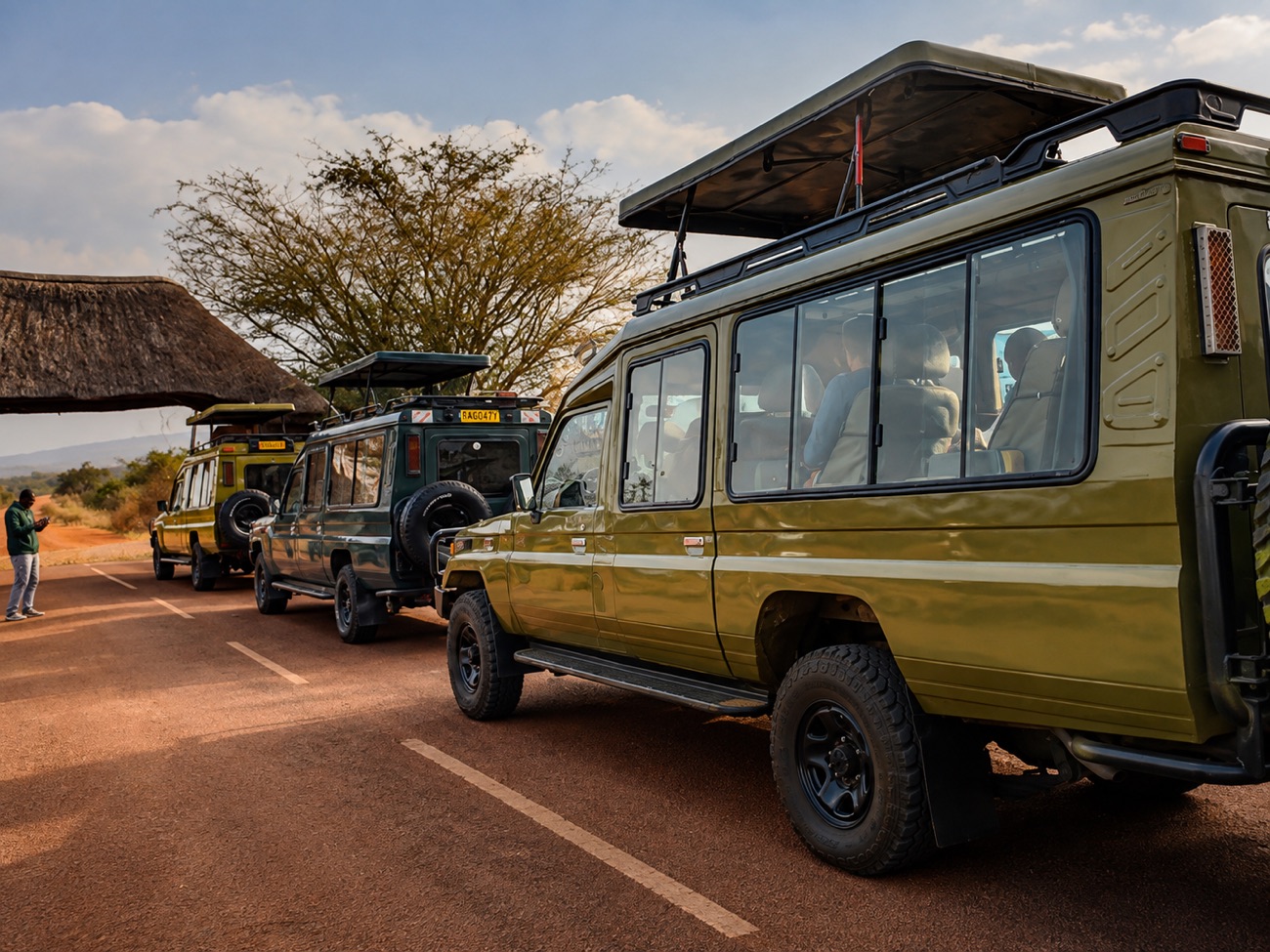 Safari 4x4 vehicles with a driver at a Rwanda park entrance